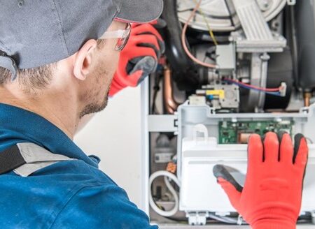 HVAC technician taking apart furnace for furnace blower motor replacement