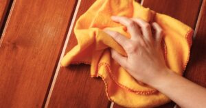 wiping wooden deck with a cloth